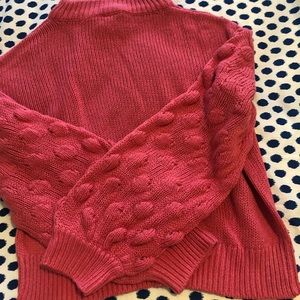 Pink cropped sweater with puff sleeves and ball details  on sleeves